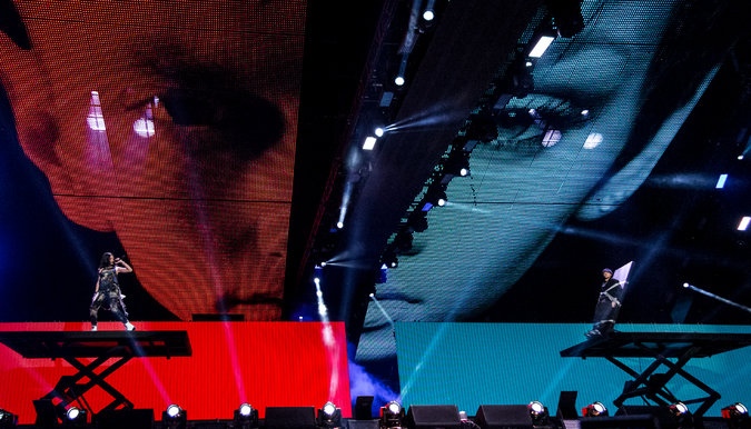 The Monster Tour, August 2014. Performers on hydraulic lifts in front of tracking video walls. Photo: New York Times.